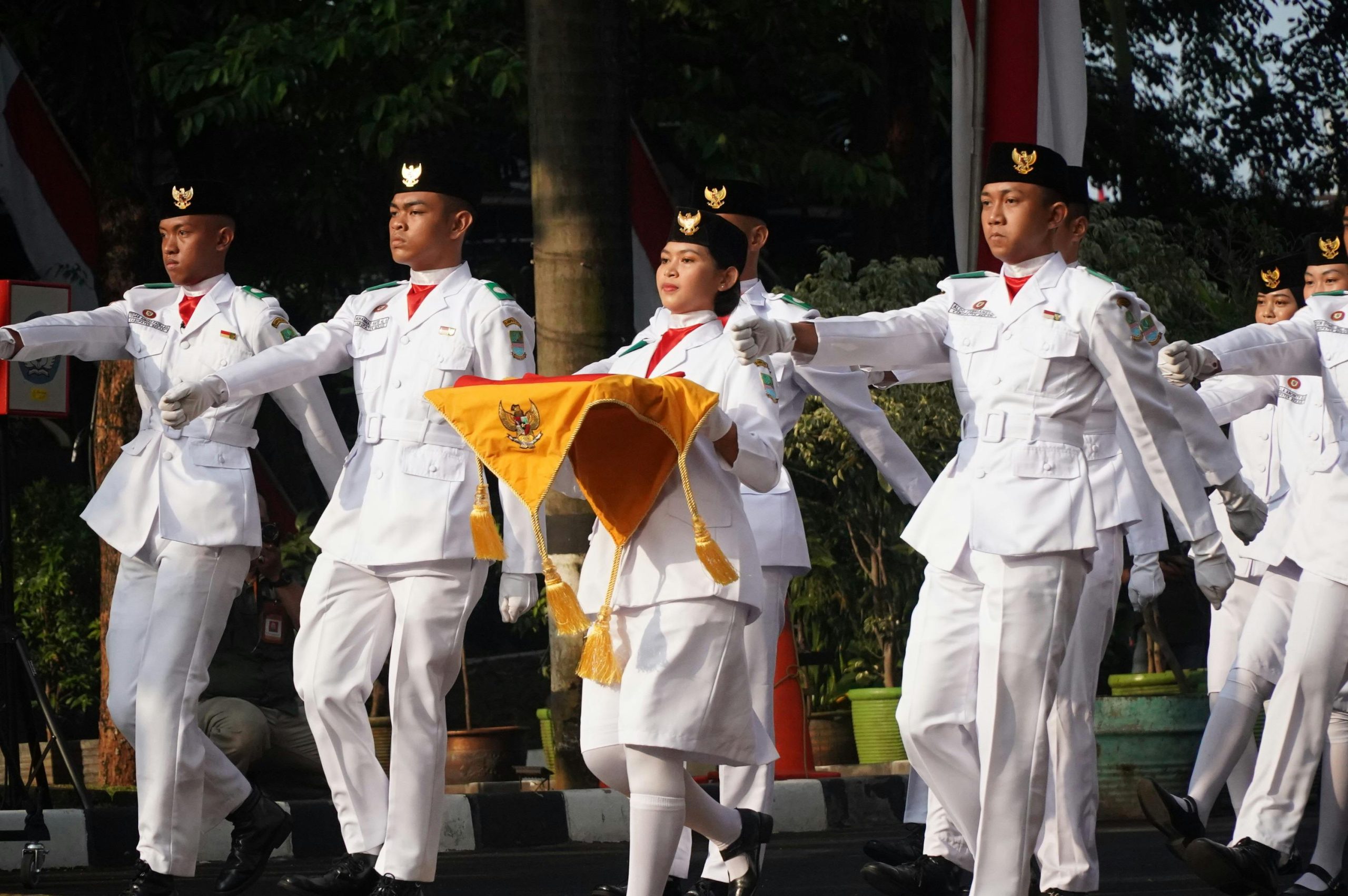 Students in ceremonial uniforms march during Indonesian Independence Day celebration.