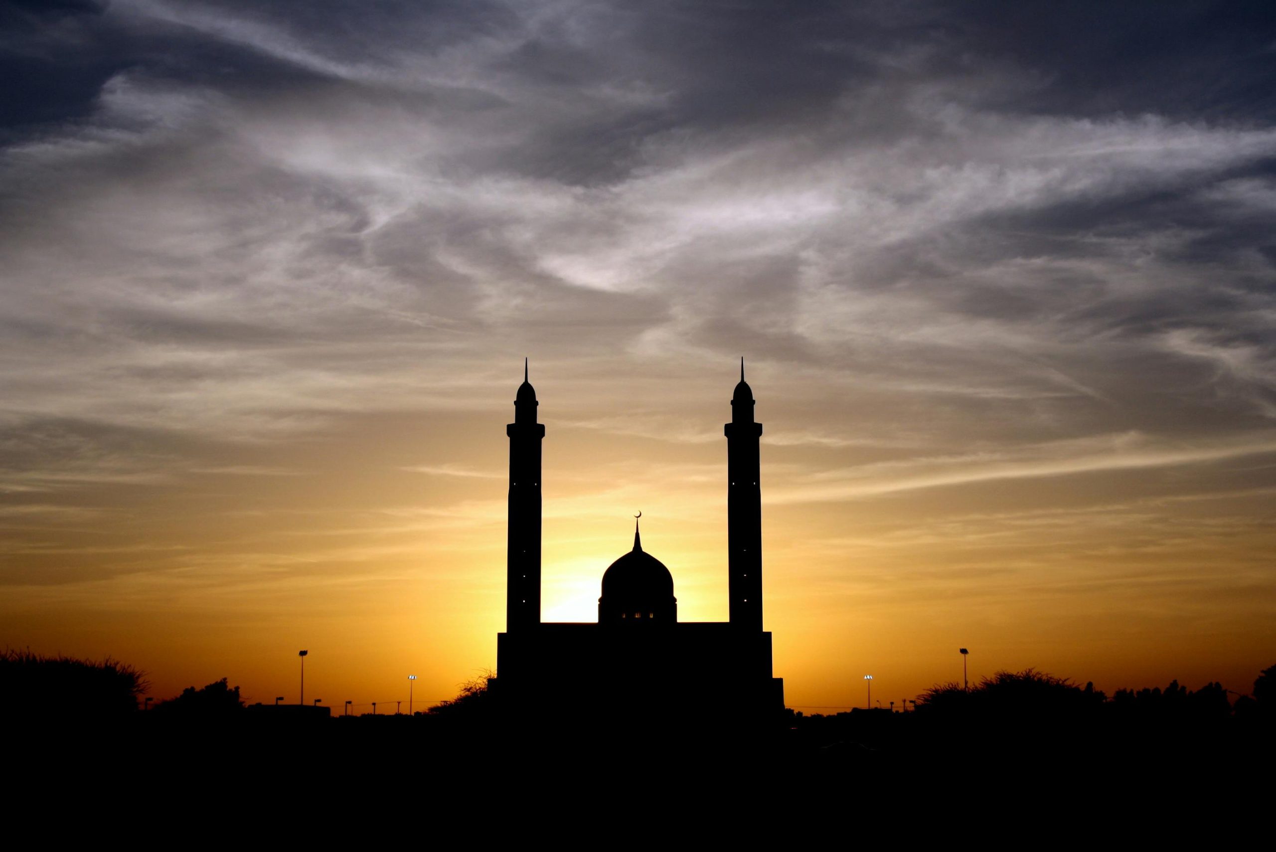 Beautiful silhouette of a mosque against a vibrant sunset sky, highlighting its architectural elegance.